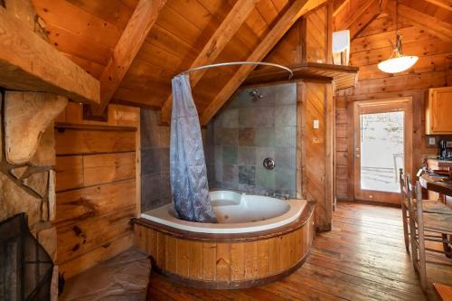 a large wooden bathroom with a tub in a cabin at Cute Studio Cabin! Views! Private. Hot Tub. Relax! in Sevierville
