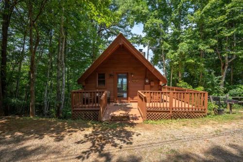 a cabin in the woods with a porch and a deck at Cute Studio Cabin! Views! Private. Hot Tub. Relax! in Sevierville