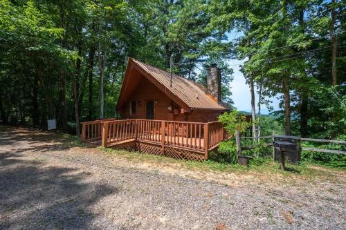 a log cabin in the woods with a fence at Cute Studio Cabin! Views! Private. Hot Tub. Relax! in Sevierville