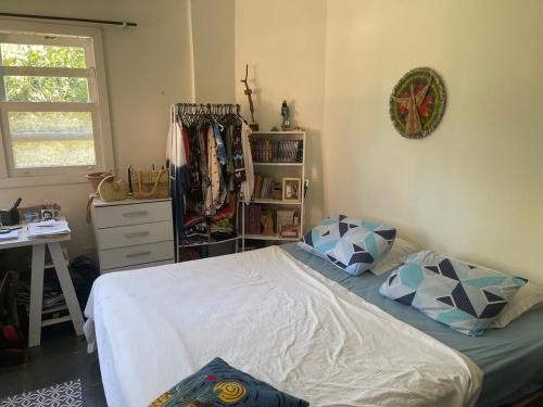 ein Schlafzimmer mit Bett, Schreibtisch und Fenster in der Unterkunft Casa perto do mar, conforto em meio a natureza in Búzios