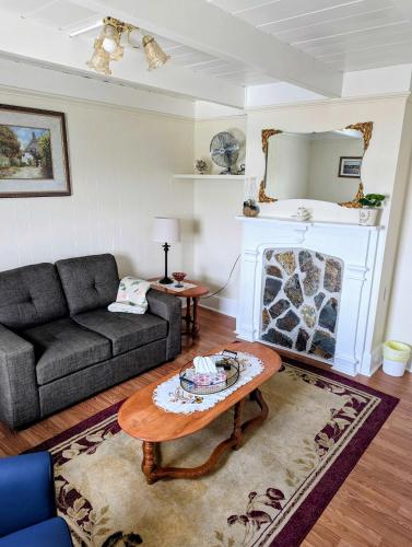 a living room with a couch and a fireplace at Historic Hillside Vacation Home in Twillingate