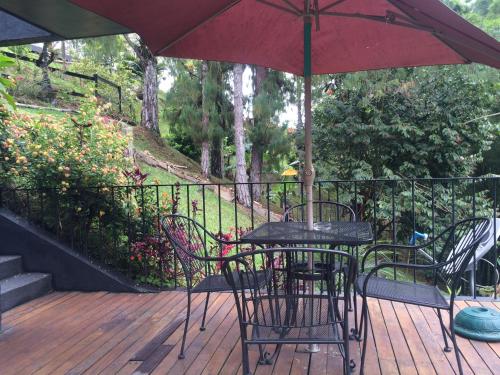 a table and chairs with an umbrella on a deck at Cabañas el Retorno in Guatapé