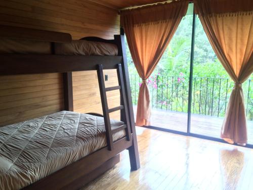 a bedroom with a bunk bed and a balcony at Cabañas el Retorno in Guatapé