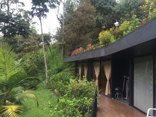 a house with a balcony with flowers on it at Cabañas el Retorno in Guatapé