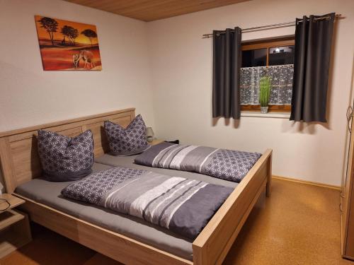 two twin beds in a room with a window at Ferienwohnung Familie Weißenbach in Elbigenalp