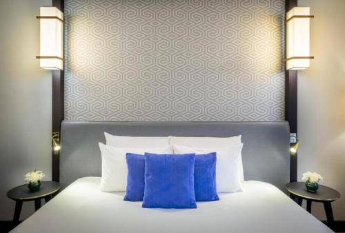 a bed with blue pillows in a hotel room at Hotel THE REGENT CROWN Near Delhi Airport in New Delhi