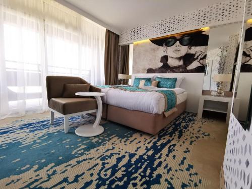 a bedroom with a bed and a chair in a room at Hotel THE REGENT CROWN Near Delhi Airport in New Delhi