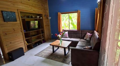 a living room with a couch and a table at Cabinas Costa Tropicana in Uvita