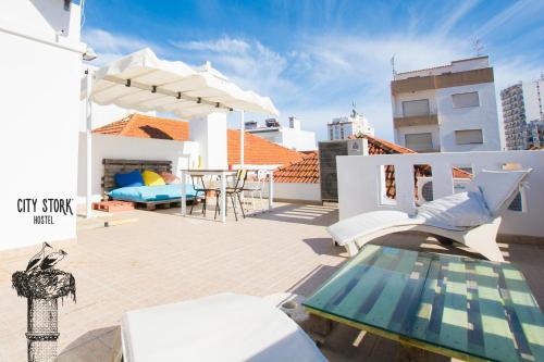 a rooftop patio with a table and chairs on a building at City Stork Hostel in Portimão