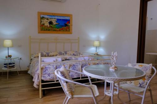a bedroom with a bed with a table and chairs at Anna's House in Borgagne