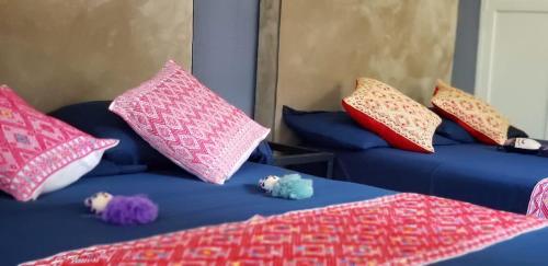a room with two beds with colorful pillows at 3 BR house 1AC y garage in Parque de la Marimba in Tuxtla Gutiérrez