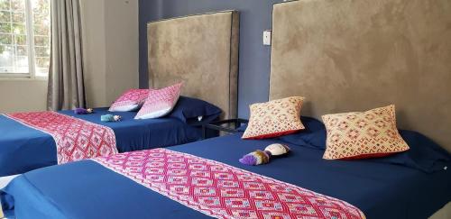 two beds with pillows on them in a room at 3 BR house 1AC y garage in Parque de la Marimba in Tuxtla Gutiérrez
