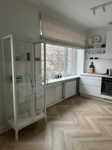 a kitchen with a glass cabinet and a window at Composer's apartment in Tallinn