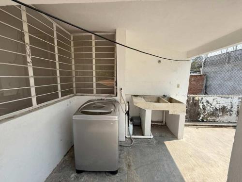 a bathroom with a sink and a trash can at 3 BR house 1AC y garage in Parque de la Marimba in Tuxtla Gutiérrez