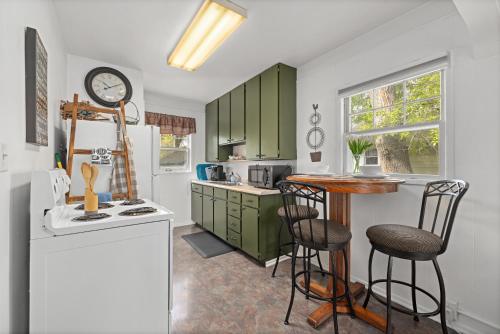 a kitchen with green cabinets and a table and chairs at Bo's Rusty Relic Central Billings near park, hospital, shared hot tub, sauna in Billings