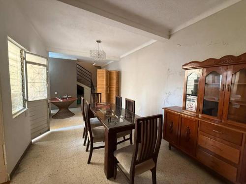 a dining room with a wooden table and chairs at 3 BR house 1AC y garage in Parque de la Marimba in Tuxtla Gutiérrez