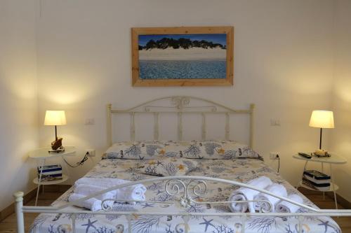 a bedroom with a white bed with two lamps at Anna's House in Borgagne