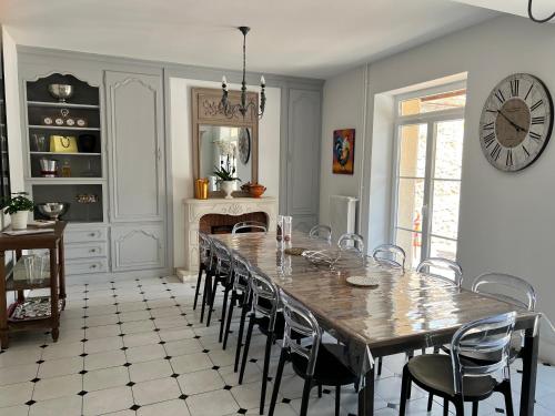 une salle à manger avec une table, des chaises et une horloge dans l'établissement Le gîte de L'Echappée Champenoise, à Sept-Saulx