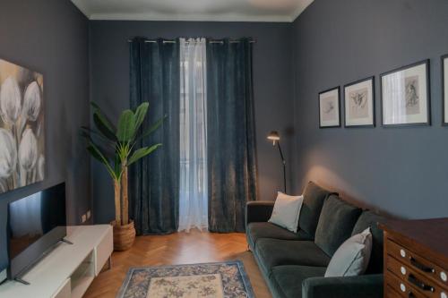 a living room with a couch and a tv at Eleganza e comfort in centro in Ivrea