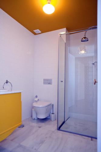 a bathroom with a glass shower and a toilet at Mercearia da Vila in Ponte de Lima