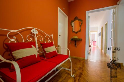 a bedroom with a red bed and a red couch at City Stork Hostel in Portimão