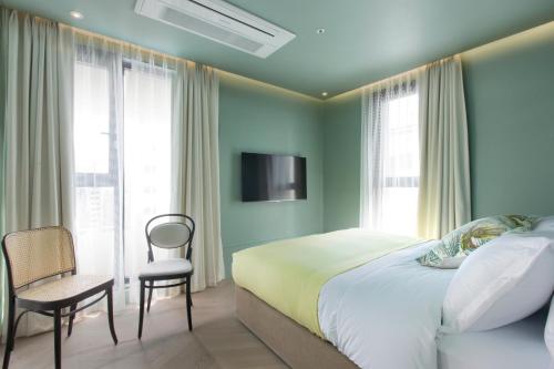 a bedroom with a bed and a chair and a tv at Stay Hotel Gangnam in Seoul
