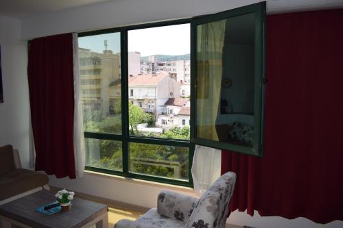 a room with a chair and a window with a view at River Harmony Apartment in Mostar