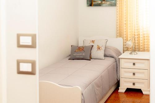 a small bedroom with a white bed and a dresser at Le Stanze di Lucia vicino Ospedale Cardinale Panico a Tricase in Tricase