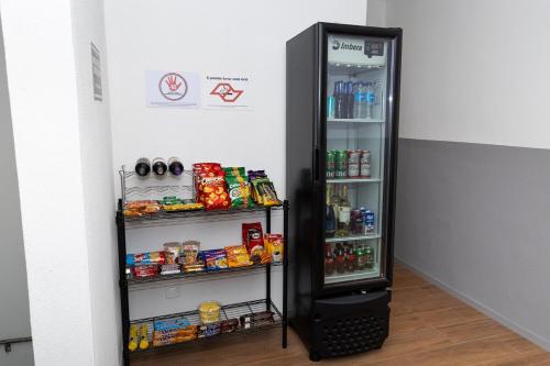 a black refrigerator with its door open and food inside at Guaja 745 - Apartamento Marie Lili in Belo Horizonte