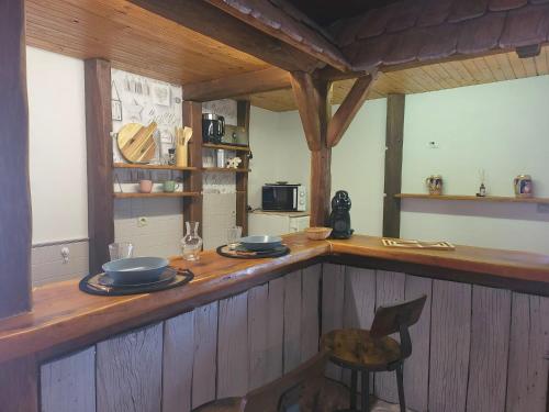 a kitchen with a counter with plates and a chair at Chalet du Rhin, le coin de Mut en Alsace proche Europa Park in Muttersholtz