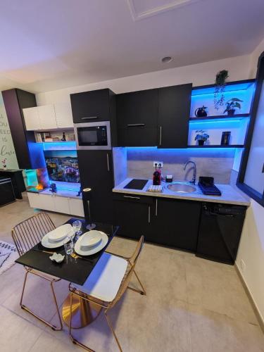 a kitchen with a sink and a table and chairs at - Aux Bulles 2 - Suite & SPA - By Skyline Résidence in Limoges