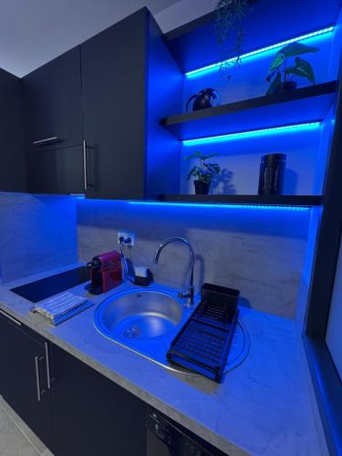 a kitchen counter with a sink with a blue light at - Aux Bulles 2 - Suite & SPA - By Skyline Résidence in Limoges