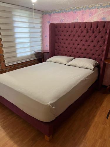 a bedroom with a large bed with a large headboard at Casa 2BR con entrepiso y AC in Zona Centro in Tuxtla Gutiérrez