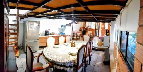 a dining room with a table and chairs and a kitchen at Casa 2BR con entrepiso y AC in Zona Centro in Tuxtla Gutiérrez