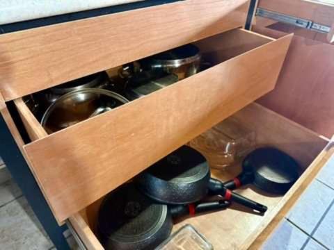 a wooden drawer filled with pots and pans at Casa 2BR con entrepiso y AC in Zona Centro in Tuxtla Gutiérrez