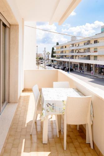 a white table and chairs on a balcony with a building at Le Stanze di Lucia vicino Ospedale Cardinale Panico a Tricase in Tricase
