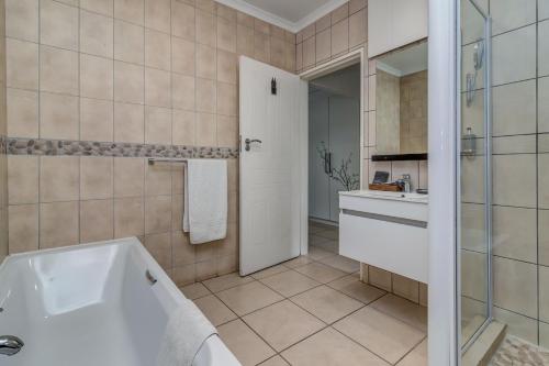 a bathroom with a tub and a sink at Sitatunga Guest Lodge in Johannesburg