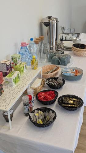 a white table with many bowls and plates on it at ZÁNKAPU -Hotel for You- Adult & Bike Friendly 3-Room B&B with Local Wine, Terrace & Káli-medence Experience in Zánka