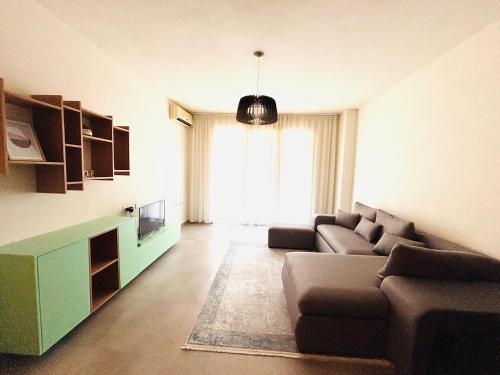 a living room with a couch and a television at Apartment Sun&Sea Durres by Sasha in Durrës