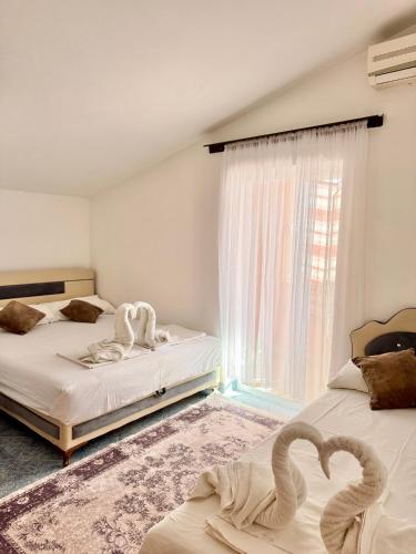 two beds in a room with two swans on them at Apartments Zeneva in Donji Štoj