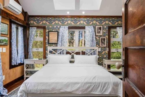a bedroom with a white bed and some windows at Swallows Nest in Salem