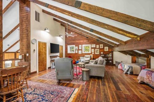 a large living room with wooden ceilings and wooden floors at Swallows Nest in Salem