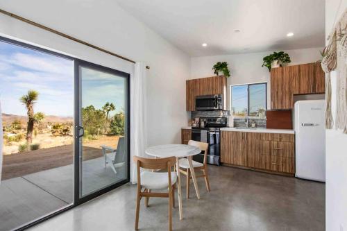 a kitchen with a table and chairs and a window at modern casita | Joshua Tree tiny home in Joshua Tree