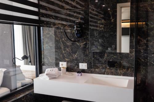 a bathroom with a white sink and a mirror at Hotel Majestic in Vlorë