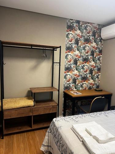 a bedroom with a bed and a table and a wall at Guaja 745 - Apartamento Luca in Belo Horizonte