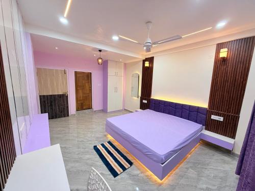 a bedroom with a bed in a room with purple walls at Alpine Nest in Dibrugarh