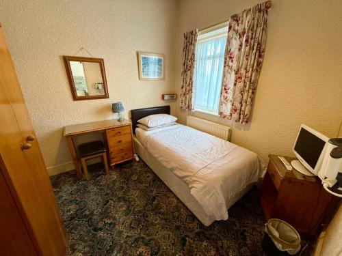 a bedroom with a bed and a desk and a window at 307 queens road Big double room with attached toilet and shower in Nottingham
