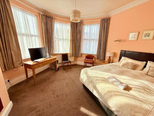 a bedroom with a bed and a desk with a computer at 307 queens road Big double room with attached toilet and shower in Nottingham