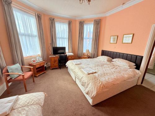 a bedroom with a bed and a desk and a television at 307 queens road Big double room with attached toilet and shower in Nottingham