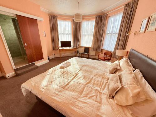 a bedroom with a large bed in a room with windows at 307 queens road Big double room with attached toilet and shower in Nottingham